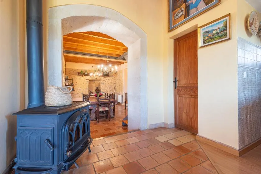 A tiled interior opens through an archway to a dining area, with a stove nearby.