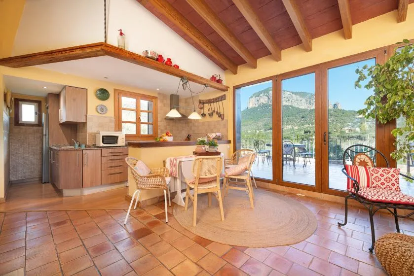 A kitchen and dining area opens onto a patio through large glass doors.