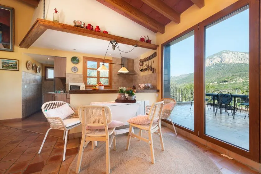 An open dining area with a table and seating beside glass doors opening onto a terrace.