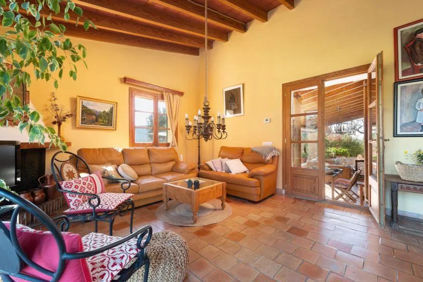 A living room with seating, a coffee table, and glass doors opening onto a patio.