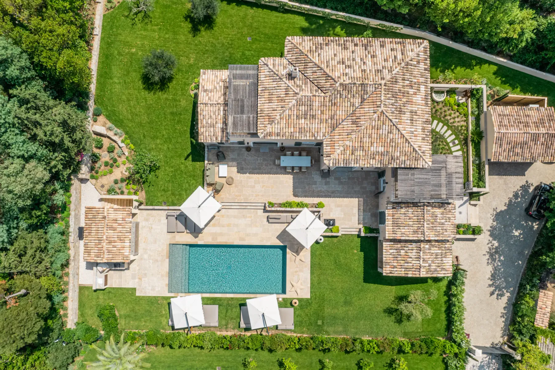 Vista aérea de una gran villa con jardín bien cuidado y piscina.