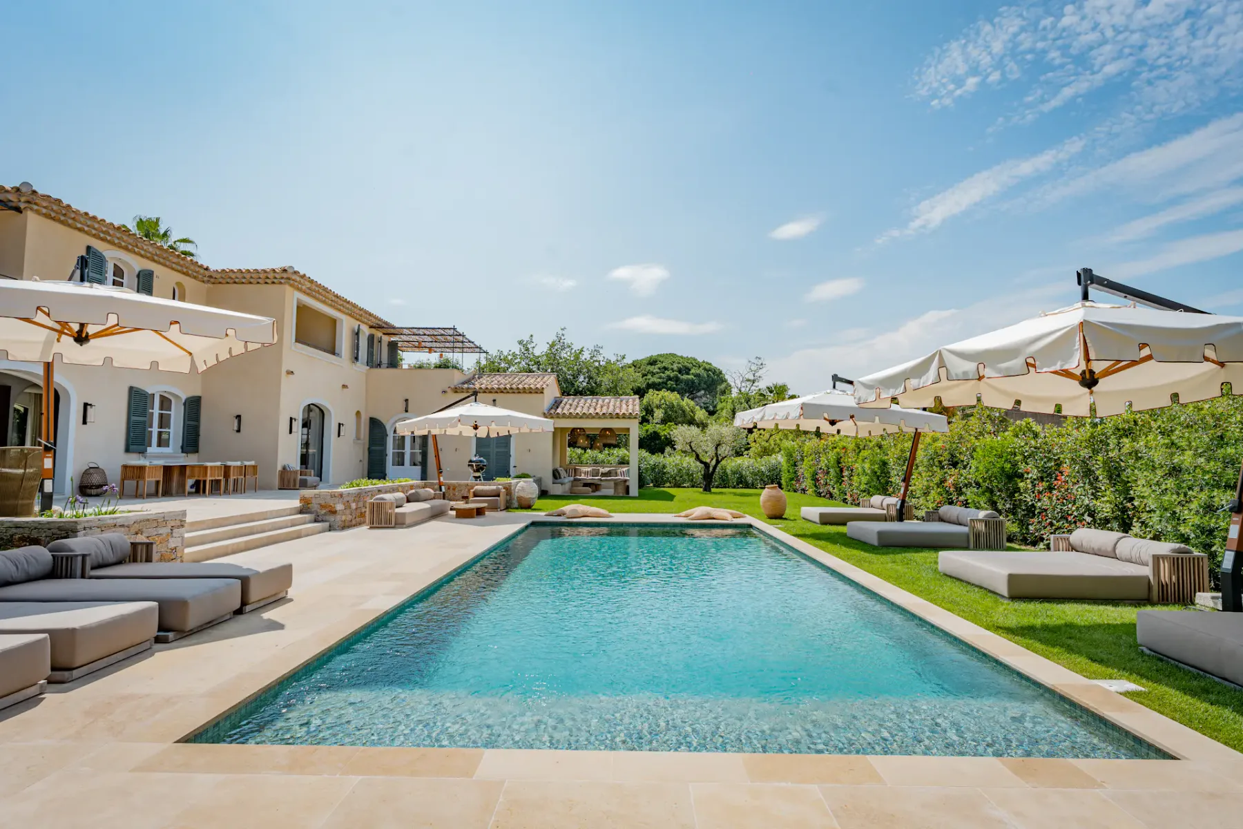 Vista de una piscina rodeada de cómodos asientos y sombrillas.