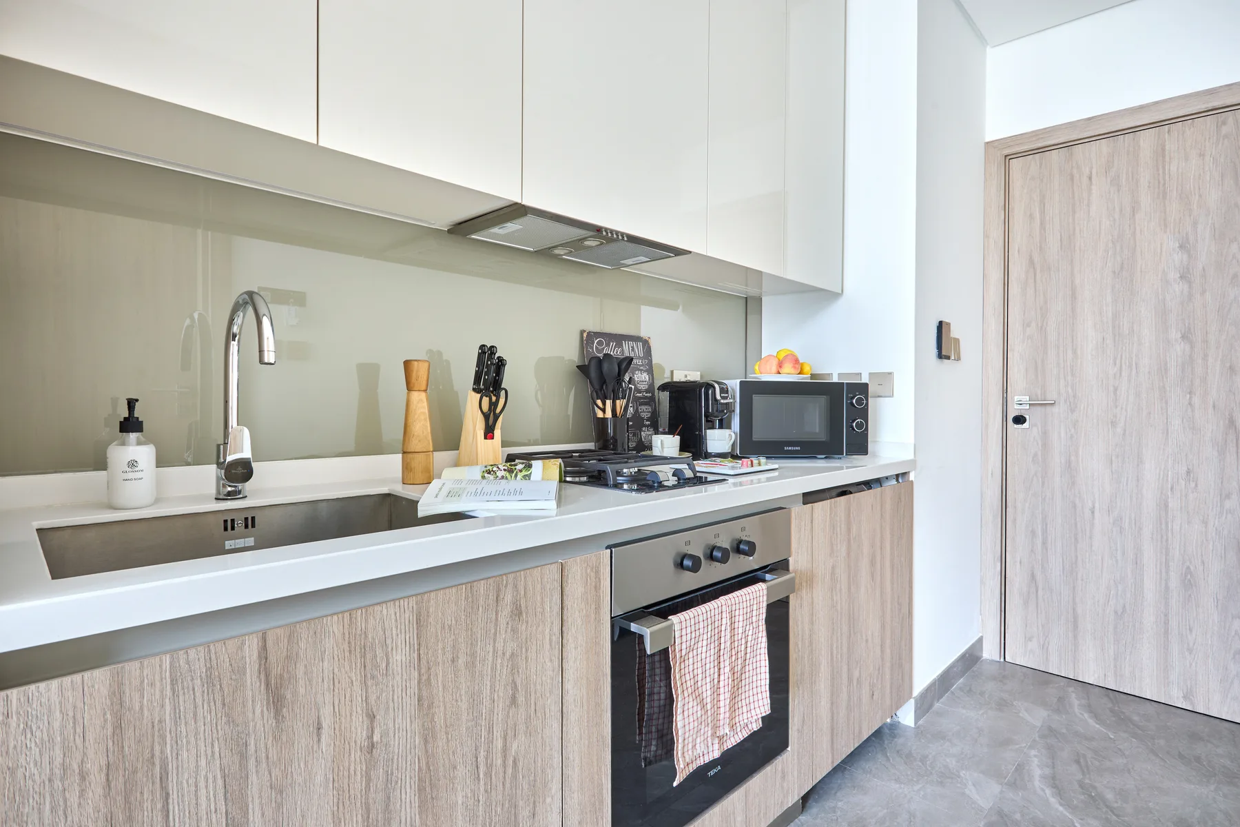 Una cocina moderna con encimera, fregadero y horno integrado.
