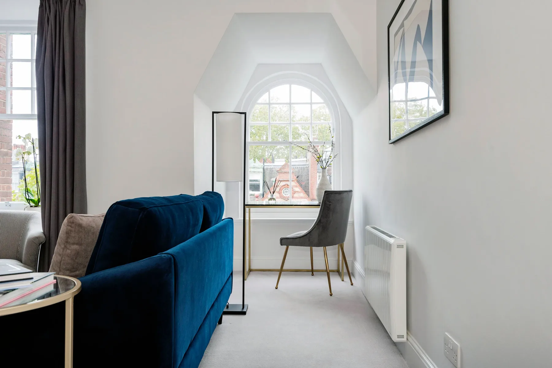 Una sala luminosa con asientos junto a una gran ventana arqueada.
