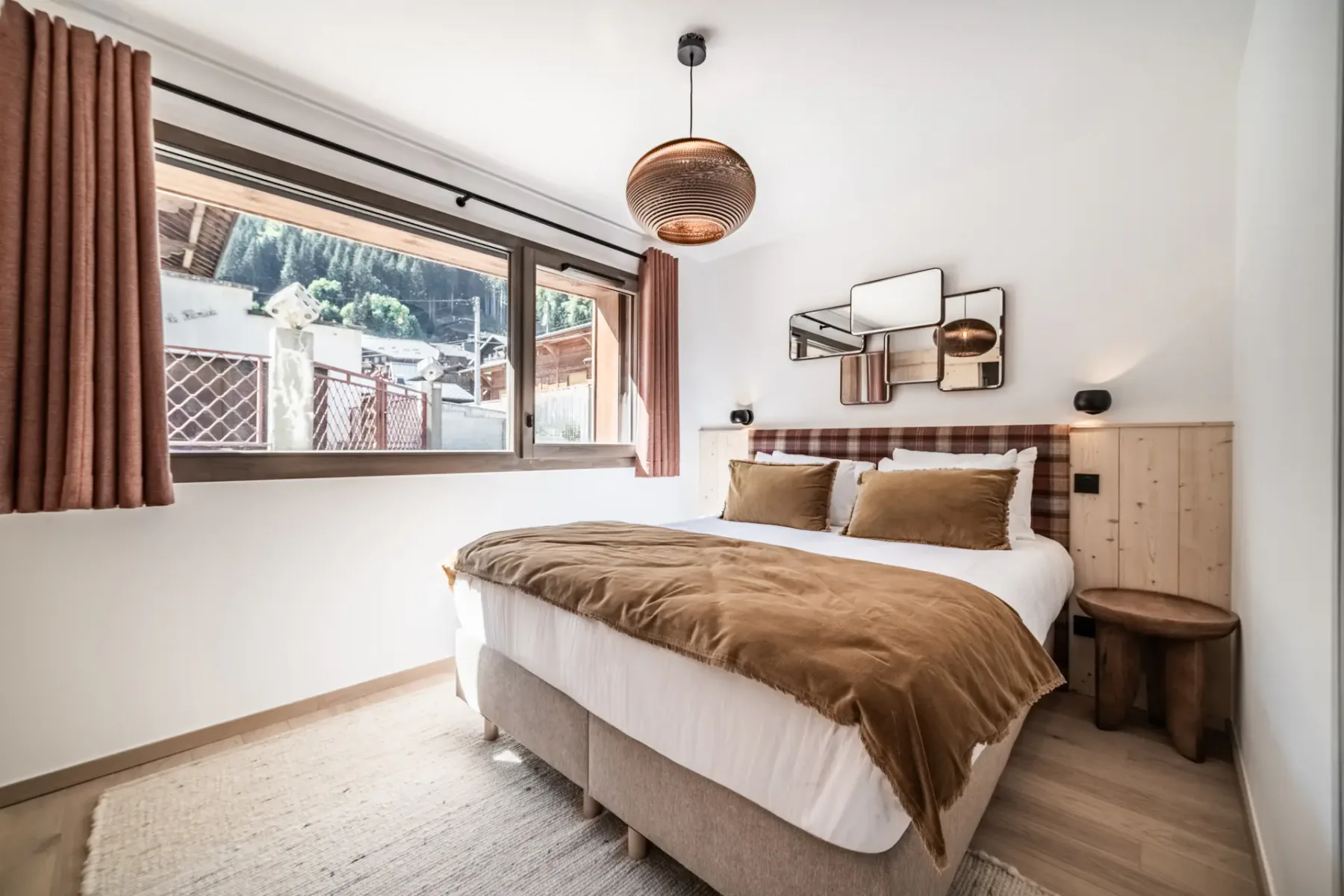 Bedroom with a bed beneath a wall-mounted decorative mirror.