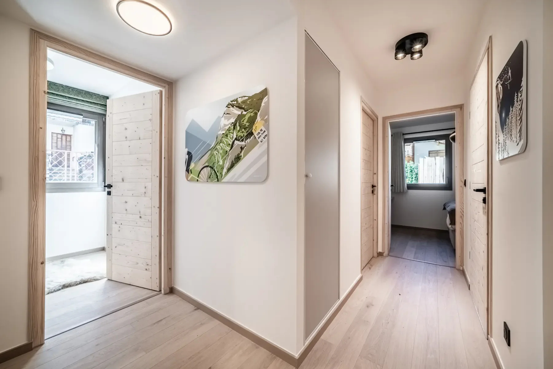 A bright hallway with light flooring and several open doorways.