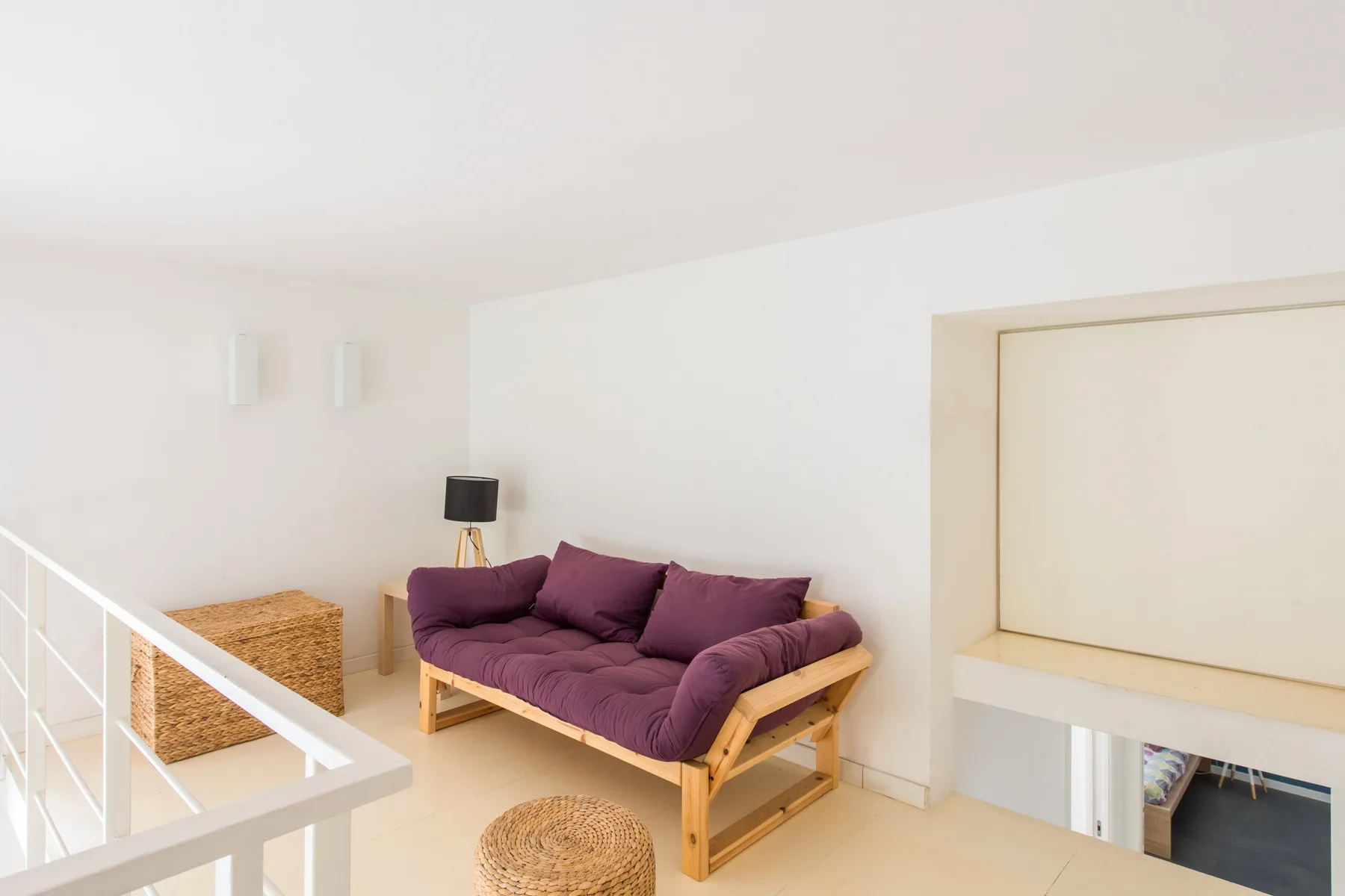A bright seating area with a purple sofa and a small side table.