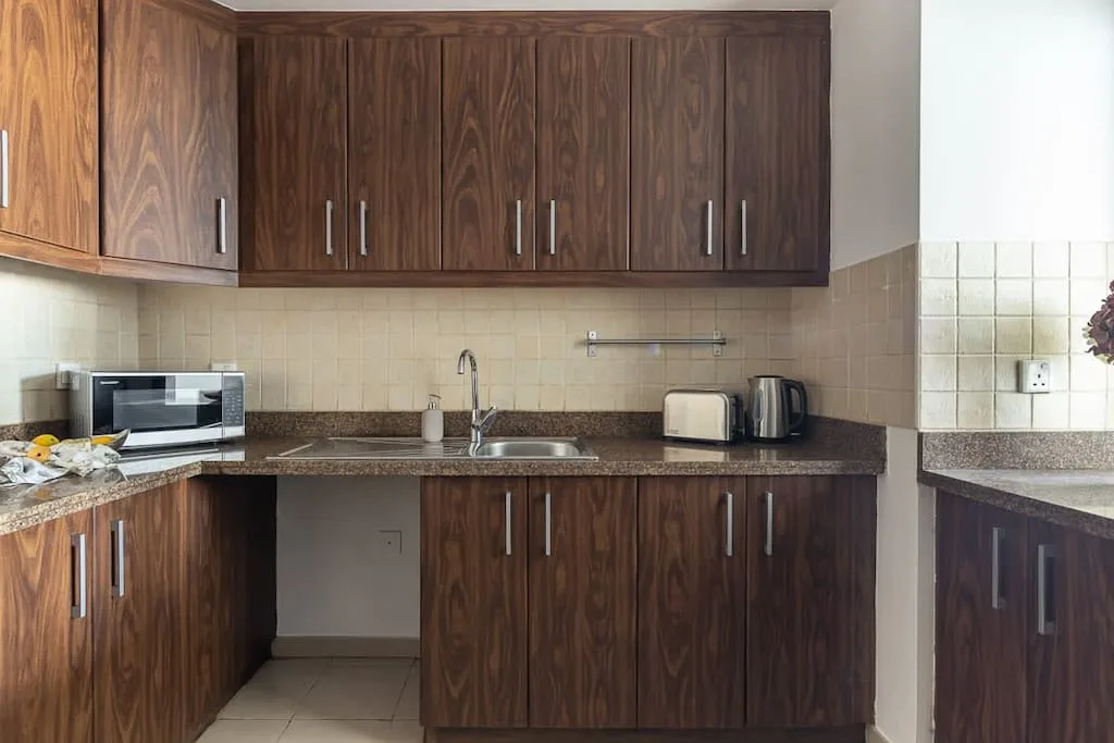Una cocina con armarios de madera oscura, encimera y fregadero.