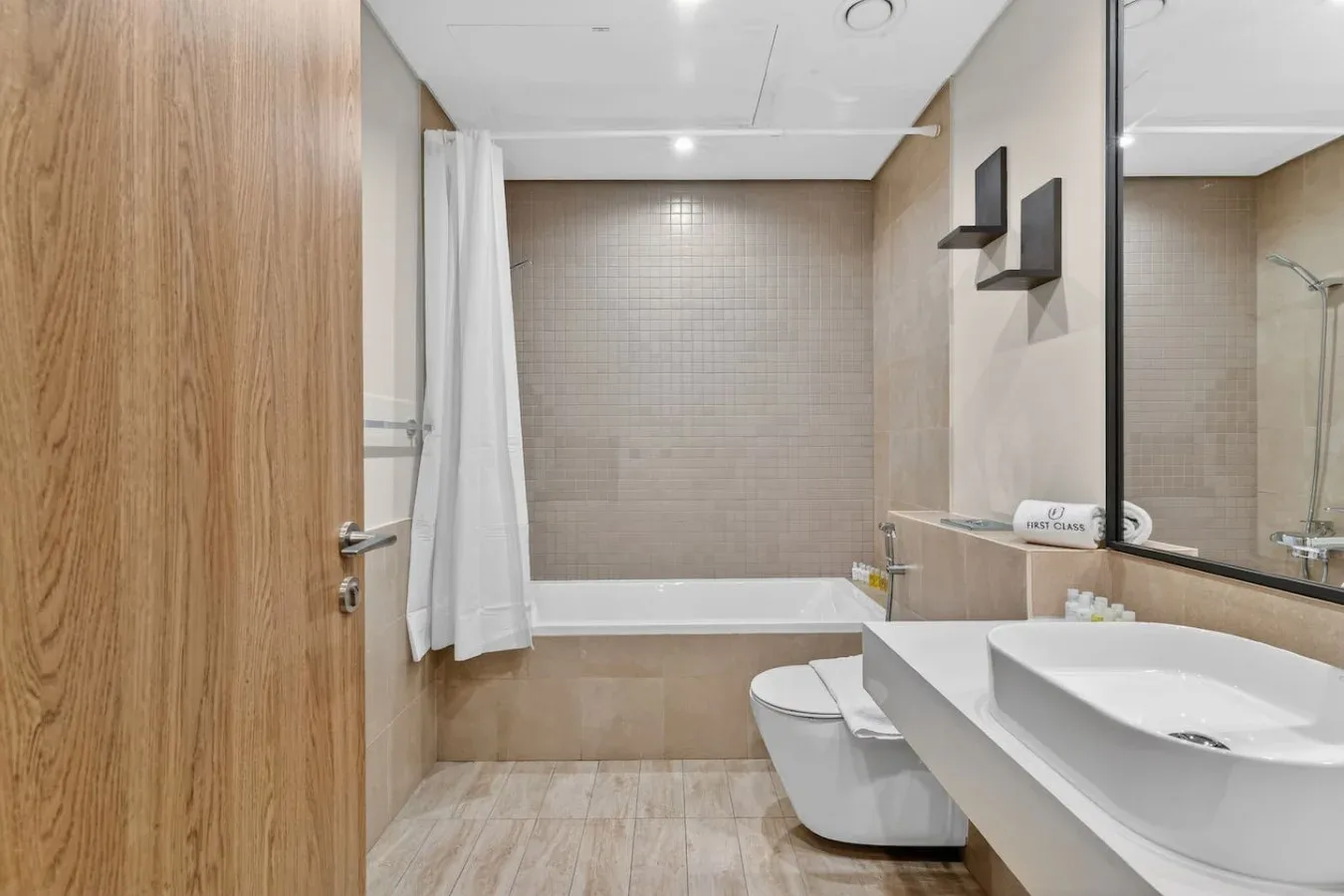 A modern bathroom with a walk-in shower, toilet, and sink.