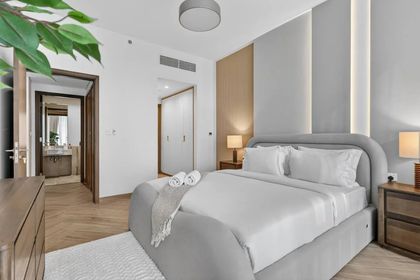A bedroom with a neatly made bed and bedside tables.