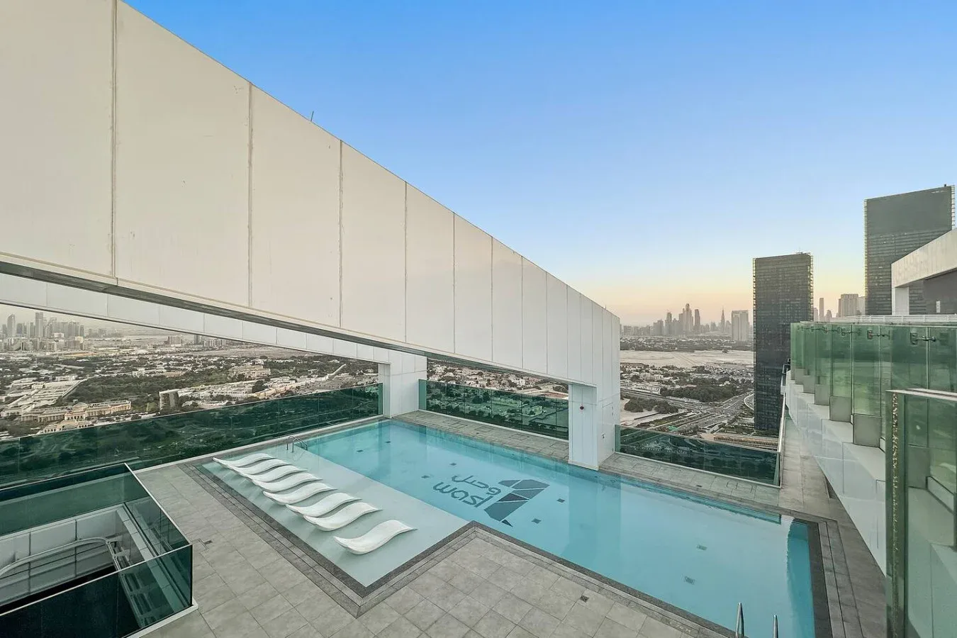 A rooftop swimming pool overlooks the city skyline.