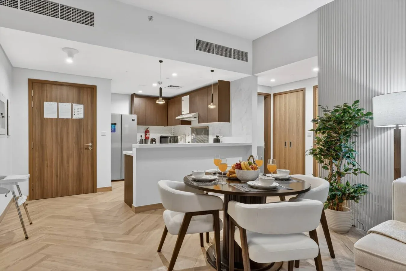 A bright open-plan kitchen and dining area with a table and surrounding seating.