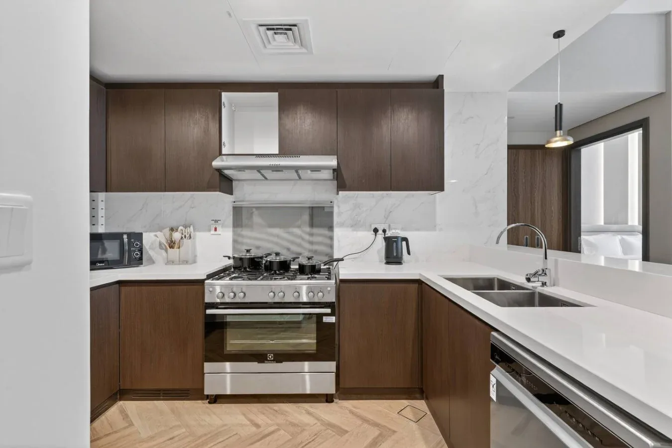 A modern kitchen with dark wood cabinets, a stainless steel range, and a white countertop.