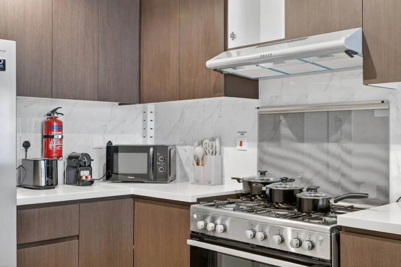 A kitchen with wood cabinets, countertop appliances, and a gas range.