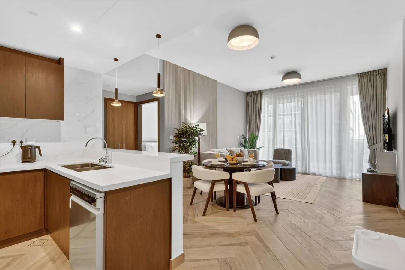 An open-plan kitchen and dining area with wood cabinetry and large windows.