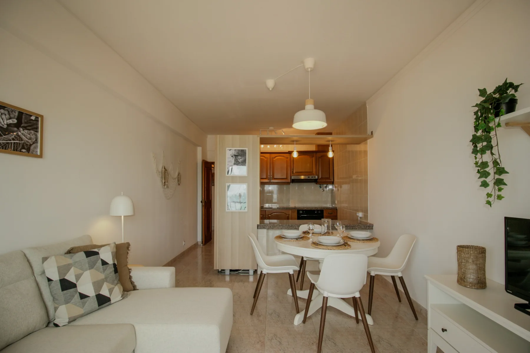 A living and dining area opens into a kitchen, with a table and seating.