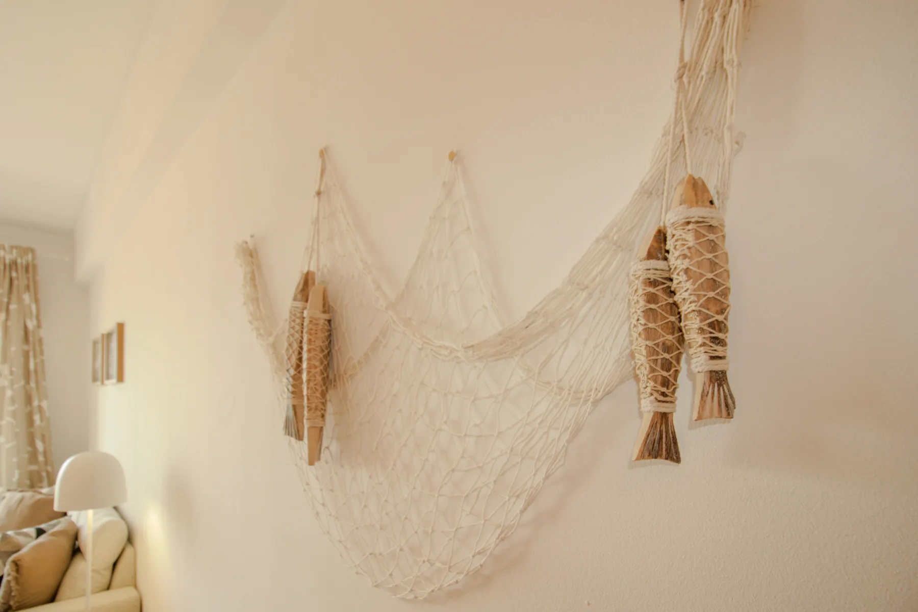 A light-colored room wall is decorated with a large woven net.