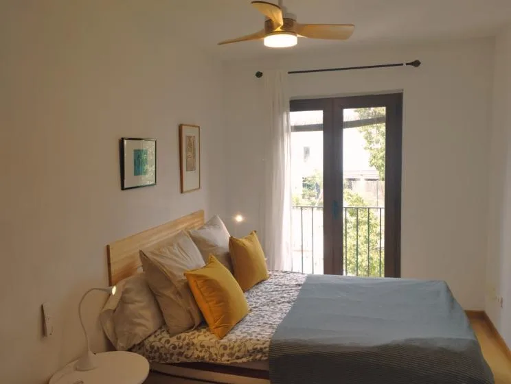 Un dormitorio con una cama junto a puertas de vidrio que dan a un balcón.