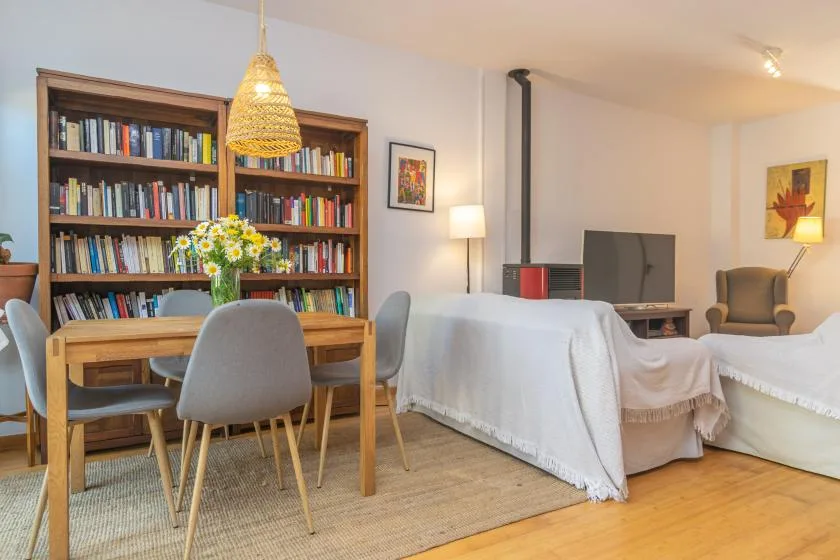 Una sala de estar con mesa de comedor, estanterías y asientos.