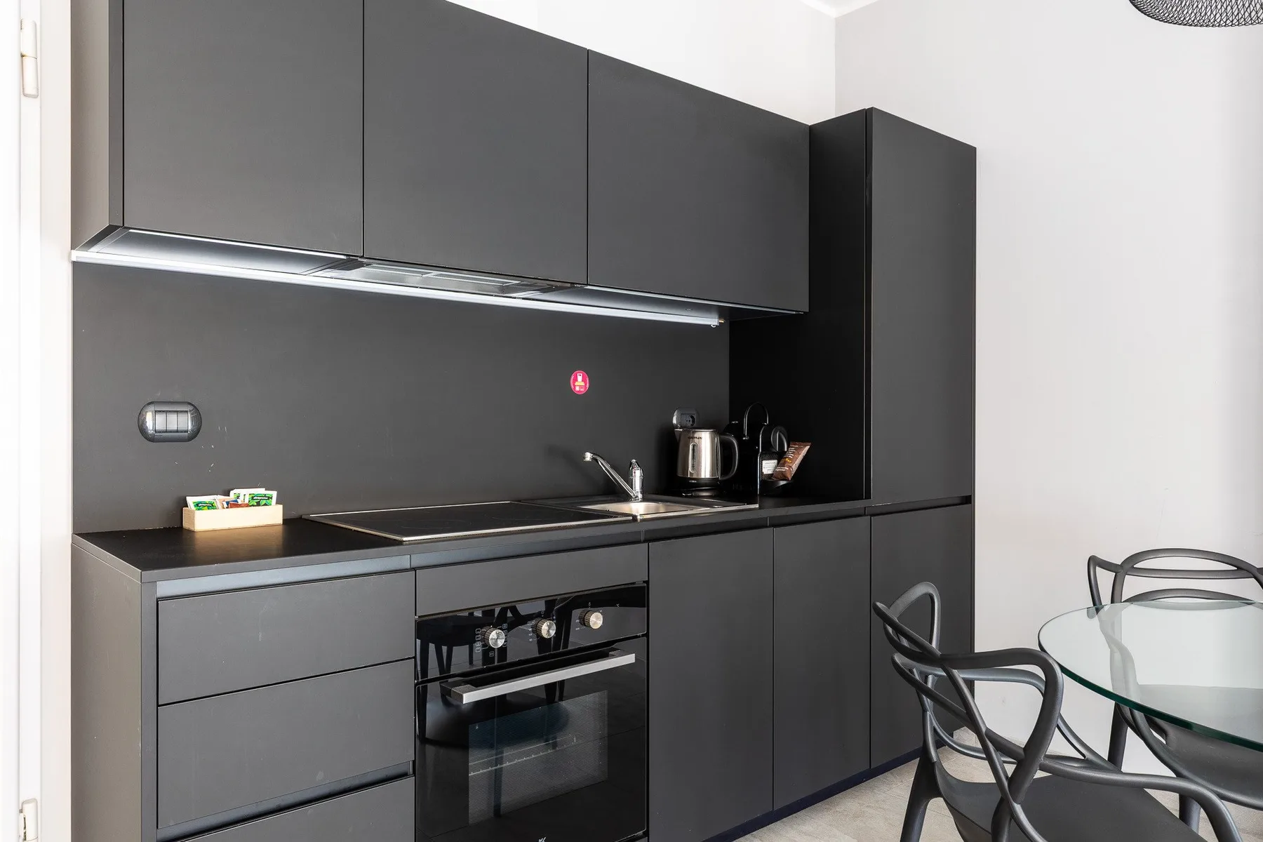 Una cocina moderna con gabinetes oscuros y una mesa de comedor.