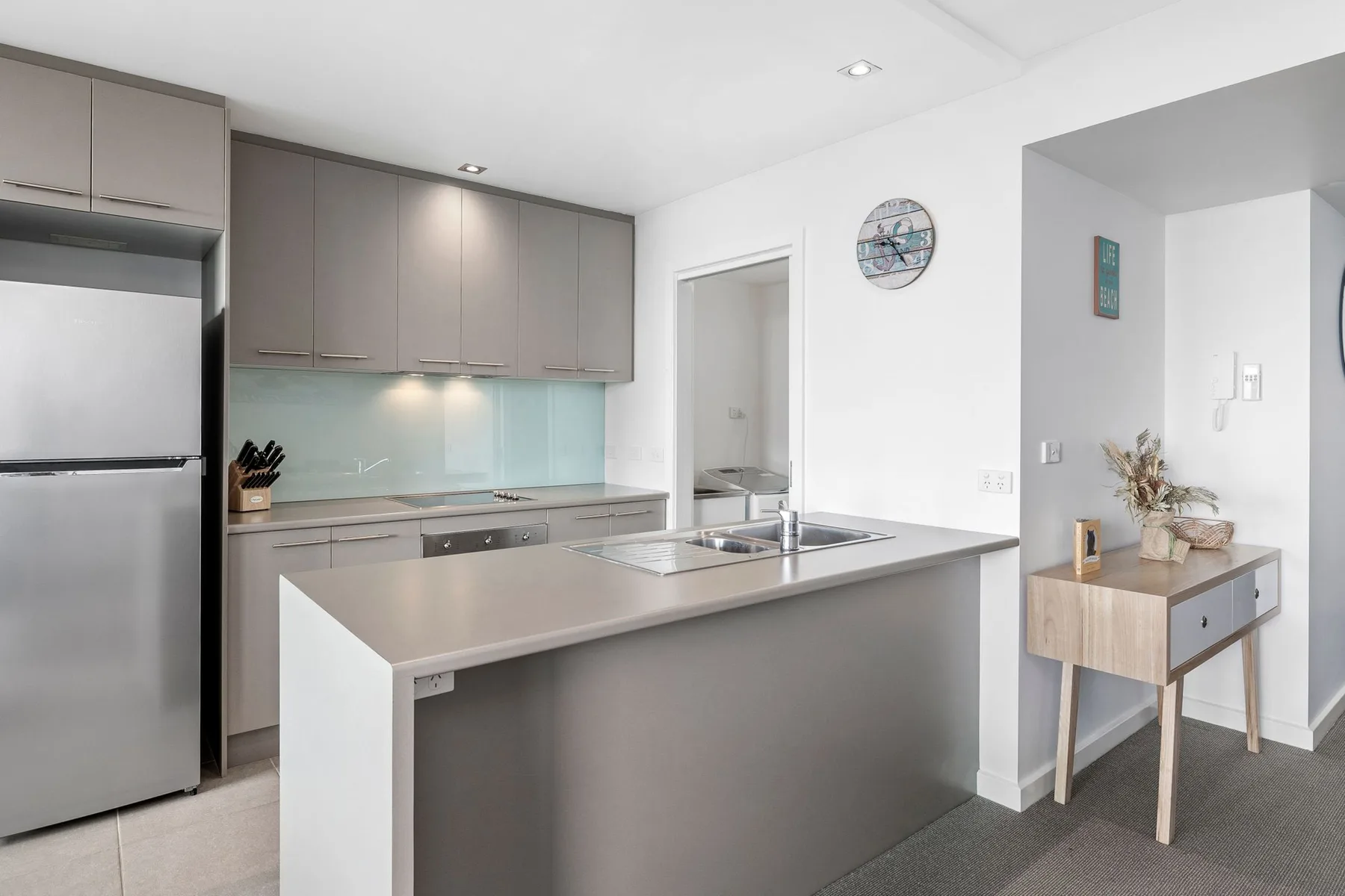A bright kitchen with gray cabinetry and a central island.