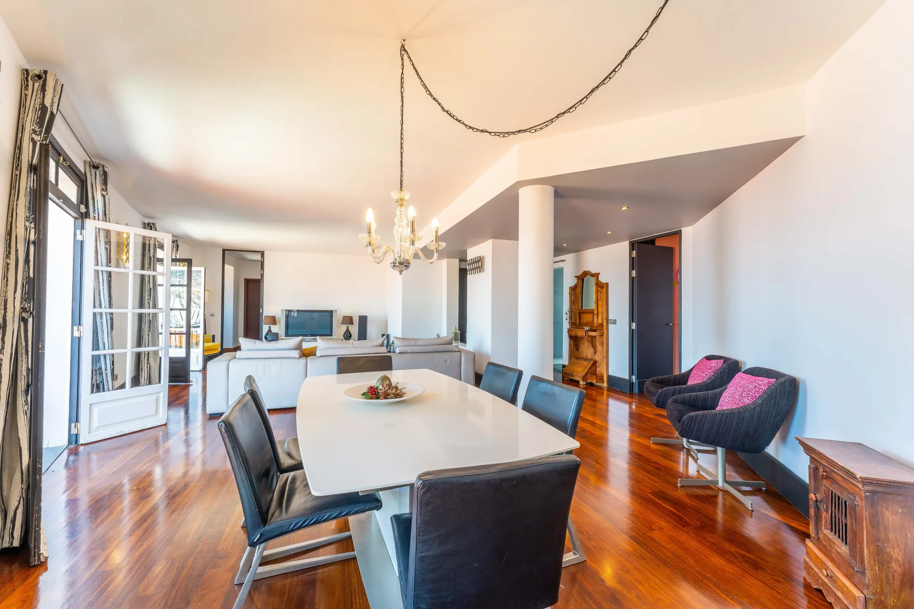 A bright open-plan living and dining area with a long table and seating.