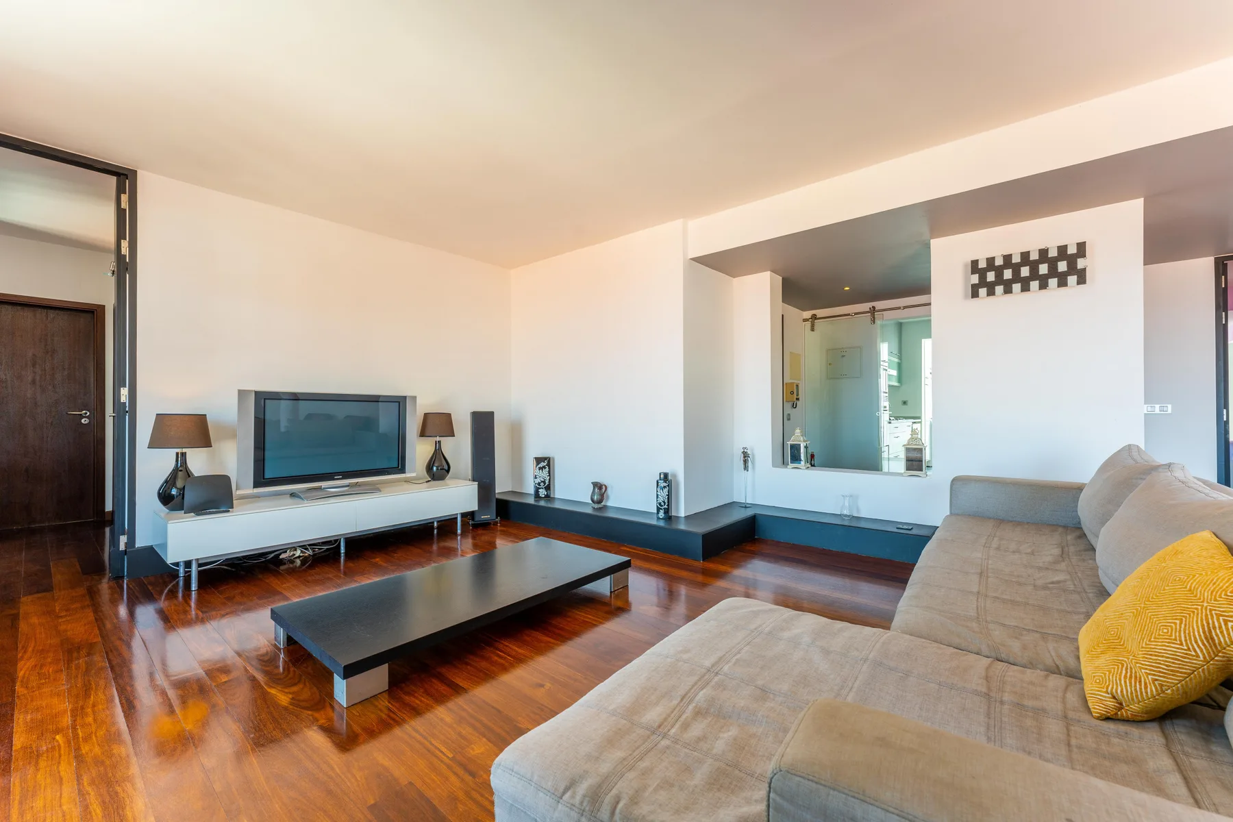 A living room with a television, low table, and seating.