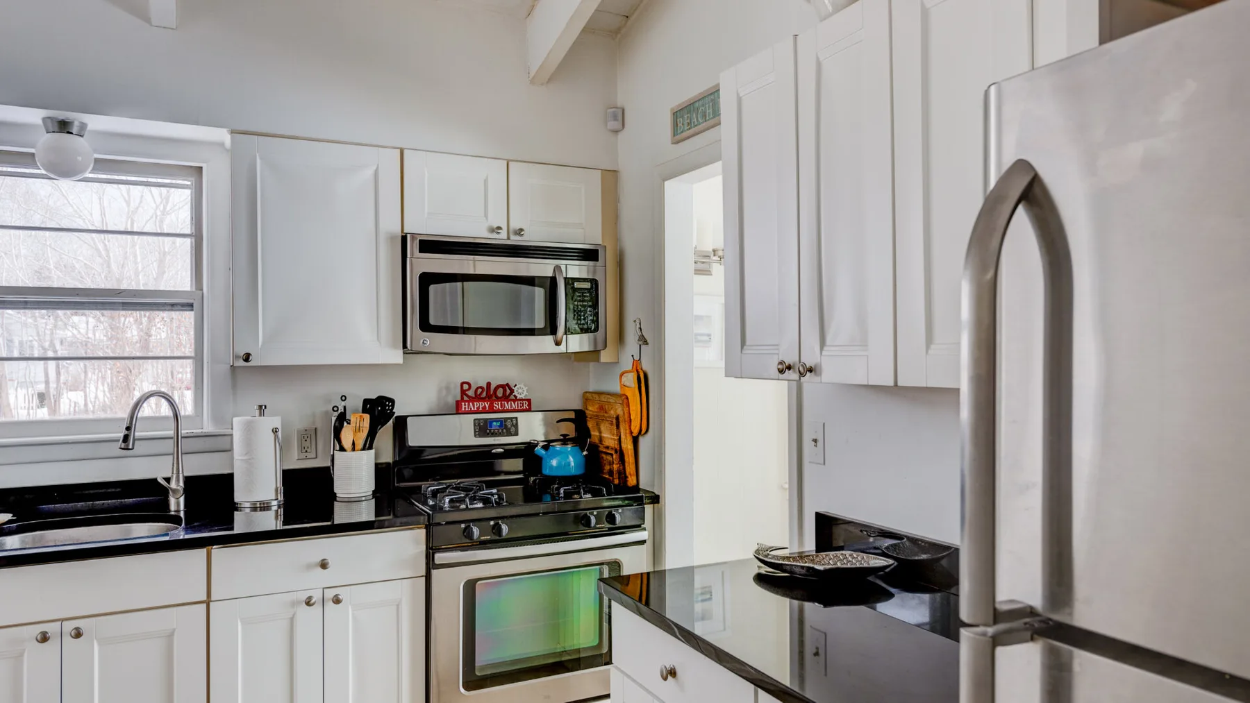 A bright kitchen with white cabinets, a stove, and a countertop.