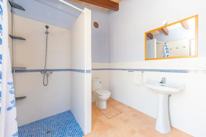 A bathroom with a shower, toilet, and pedestal sink.
