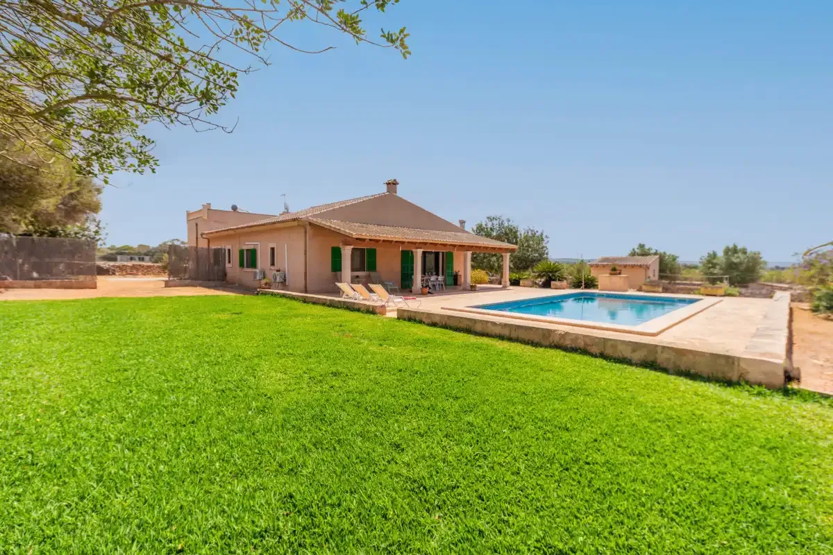 A house and swimming pool sit beside a broad green lawn.
