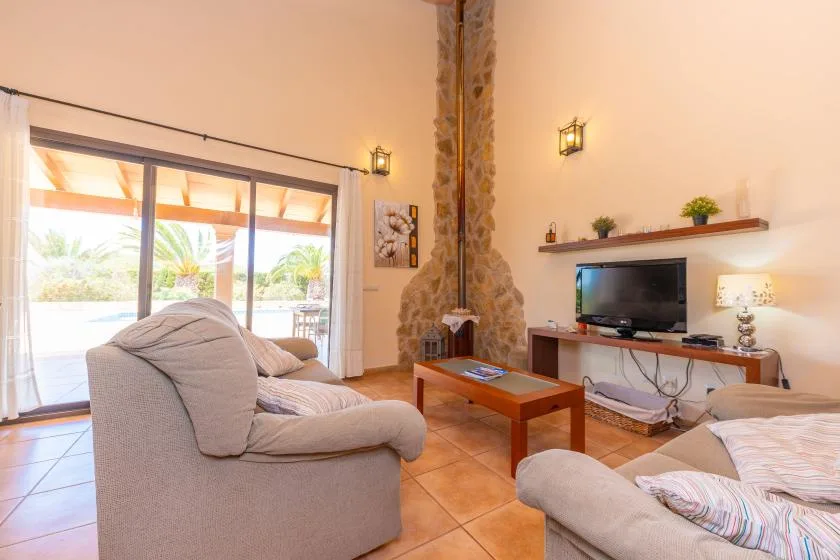 A living room with seating, a television, and sliding glass doors opening to a patio.