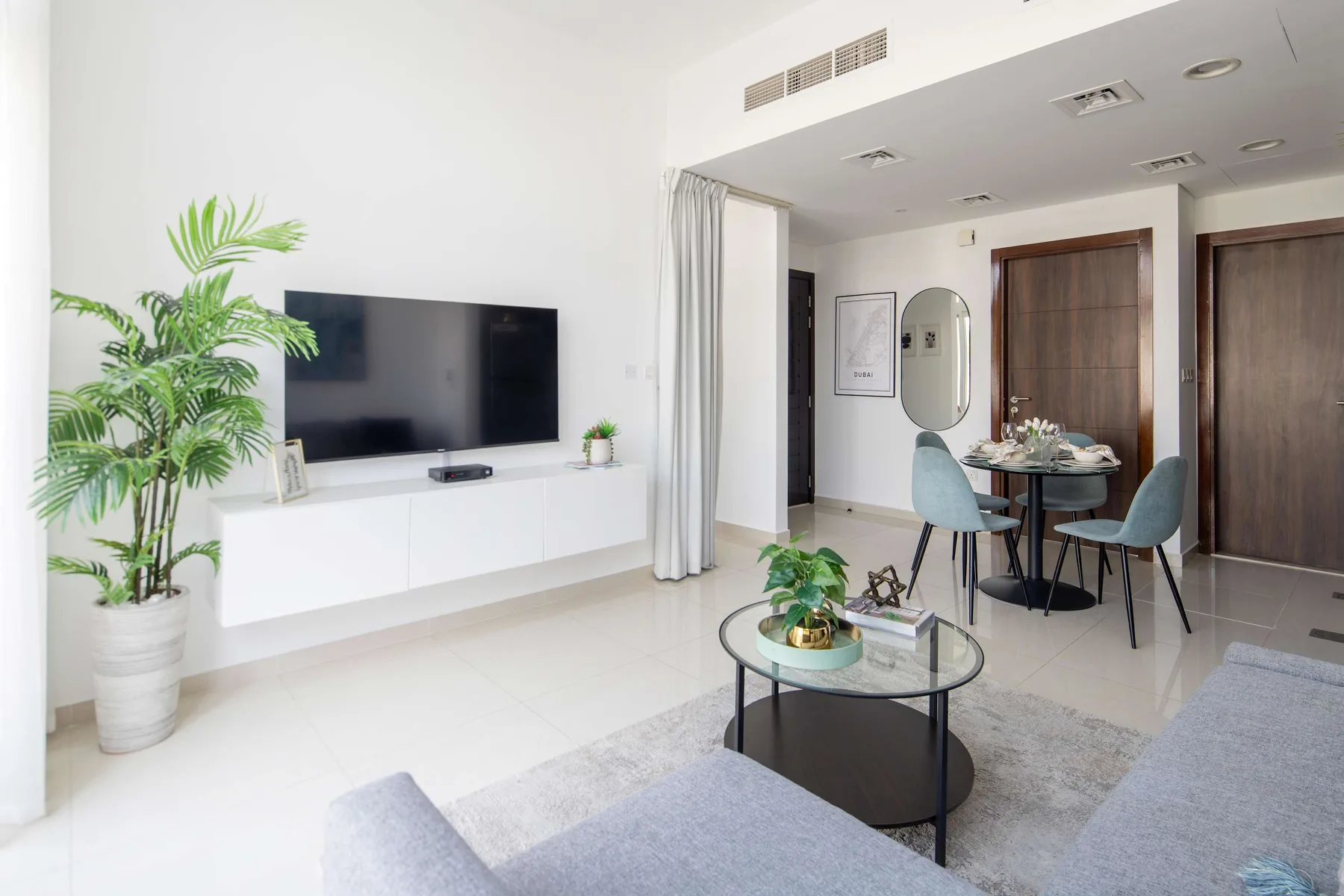 Una luminosa sala de estar y comedor con televisor, mesa de comedor y asientos.