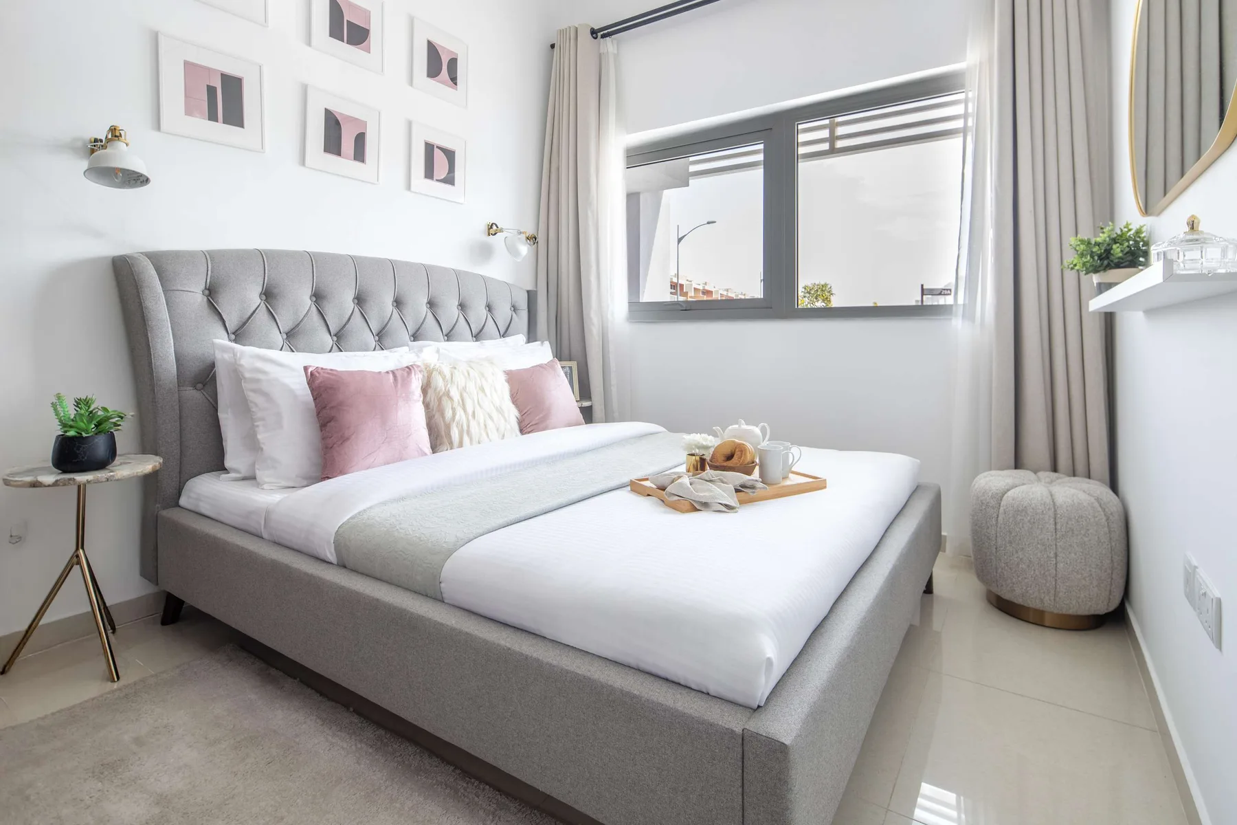 Un dormitorio luminoso con una cama bien tendida y una ventana amplia.