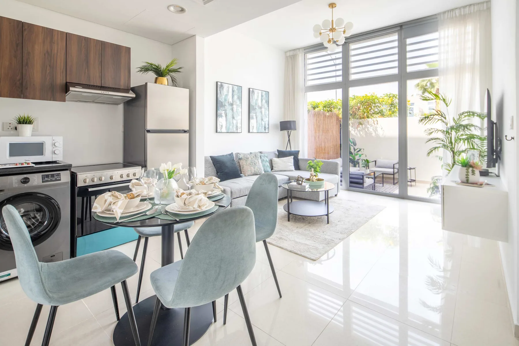Una luminosa cocina abierta al salón, con grandes ventanales y una mesa de comedor.