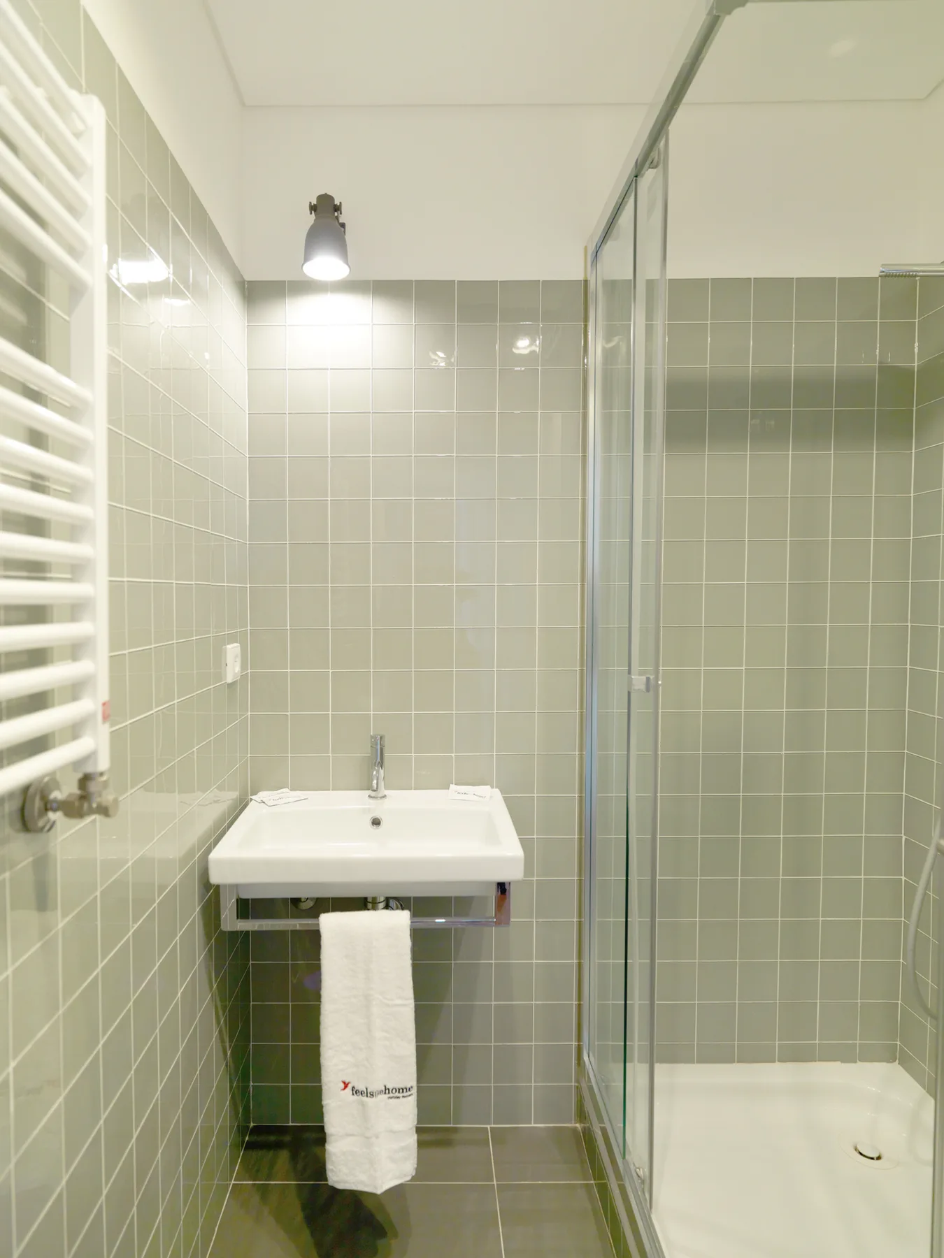 A tiled bathroom with a sink and glass shower.