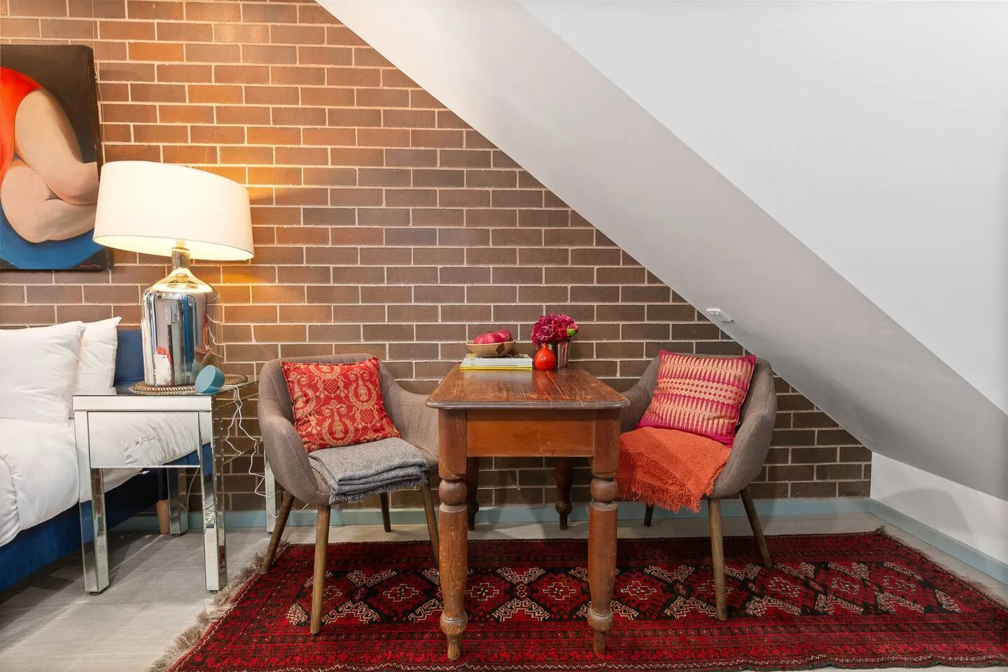 La acogedora mesa para dos está sobre una alfombra de estampado llamativo y ofrece un lugar cálido para comer algo informal o tomar un desayuno rápido.