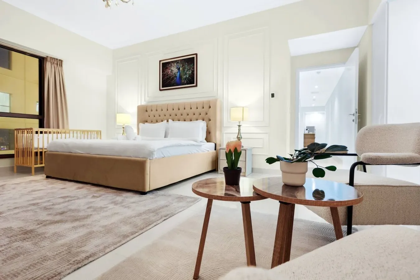 A bright bedroom with a bed, bedside tables, and a seating area.