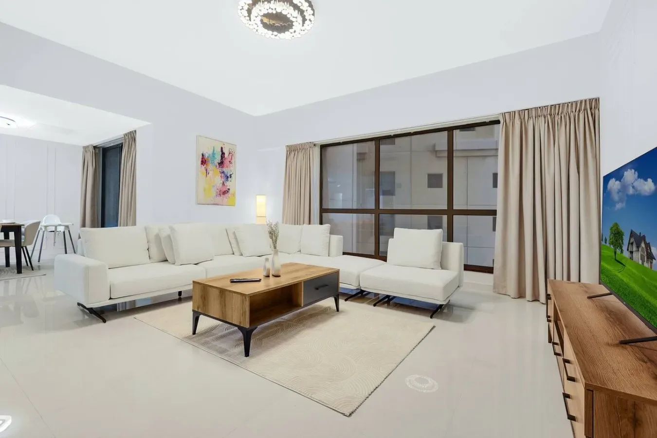 A bright living room with light seating around a wooden coffee table.