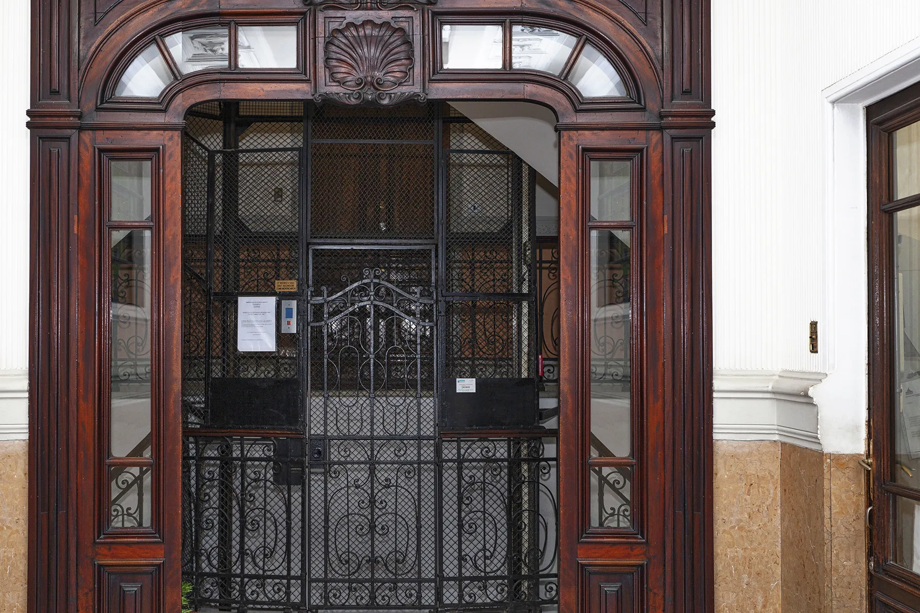 Una entrada de madera ornamentada con una reja decorativa de metal.