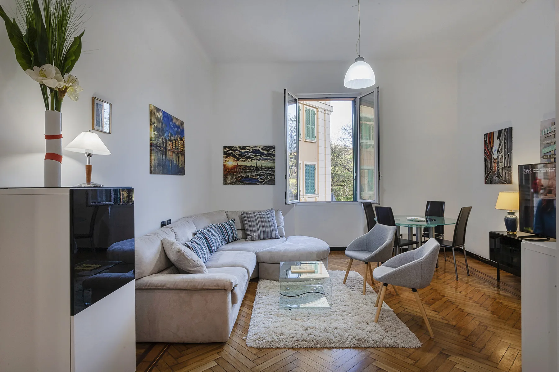 Un salón luminoso con asientos, una mesa de centro y una ventana abierta.