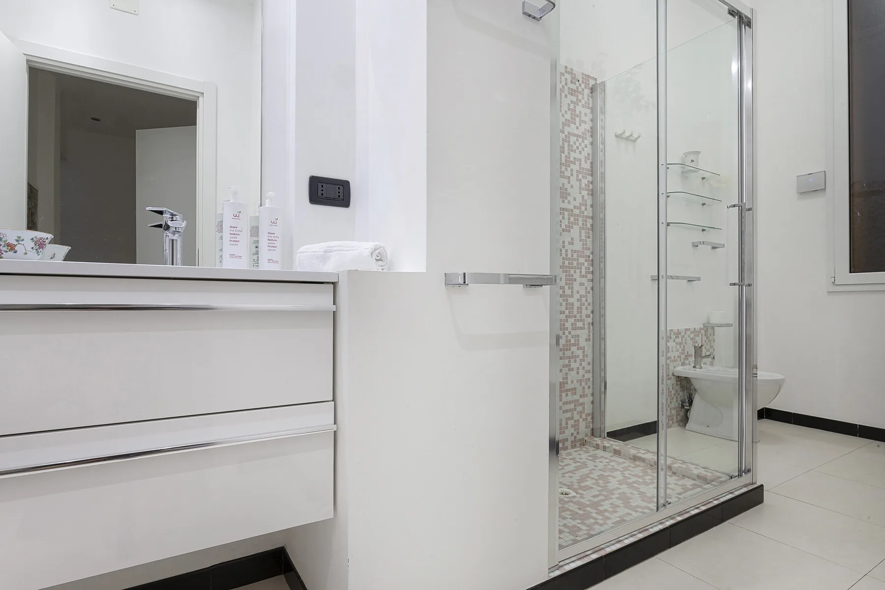 Un baño luminoso con lavabo y ducha de vidrio.
