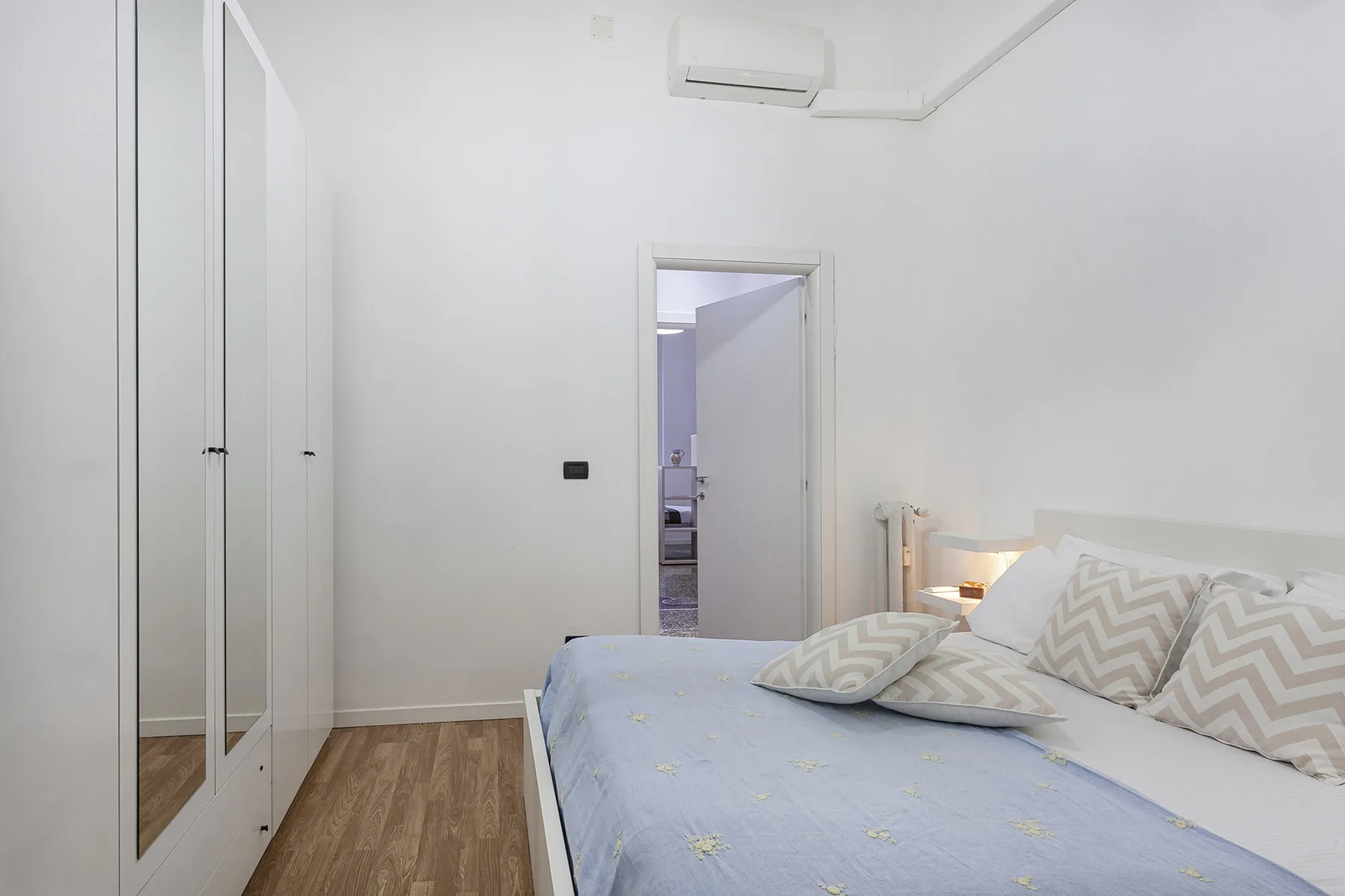 Un dormitorio luminoso con una cama y armarios empotrados.