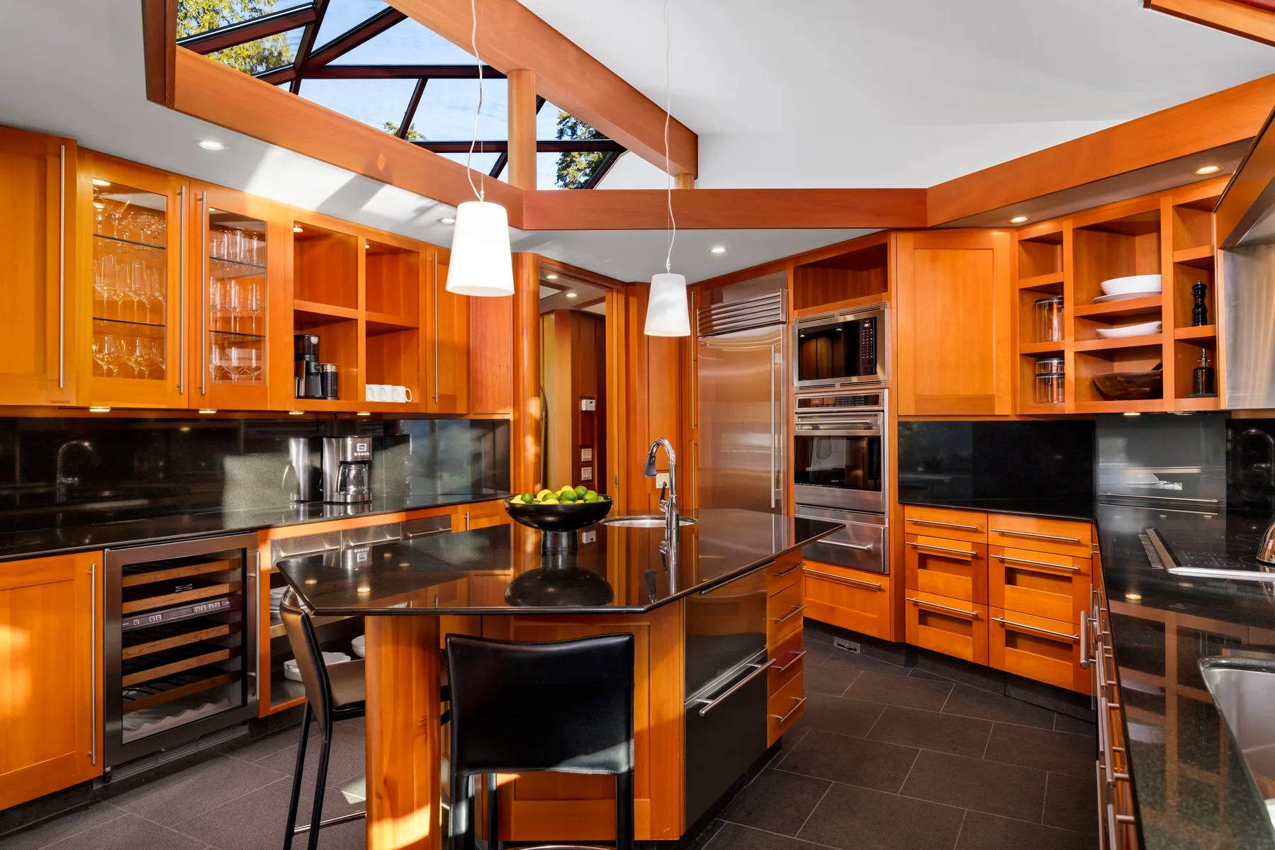 A modern kitchen with warm wood cabinetry and a central island.