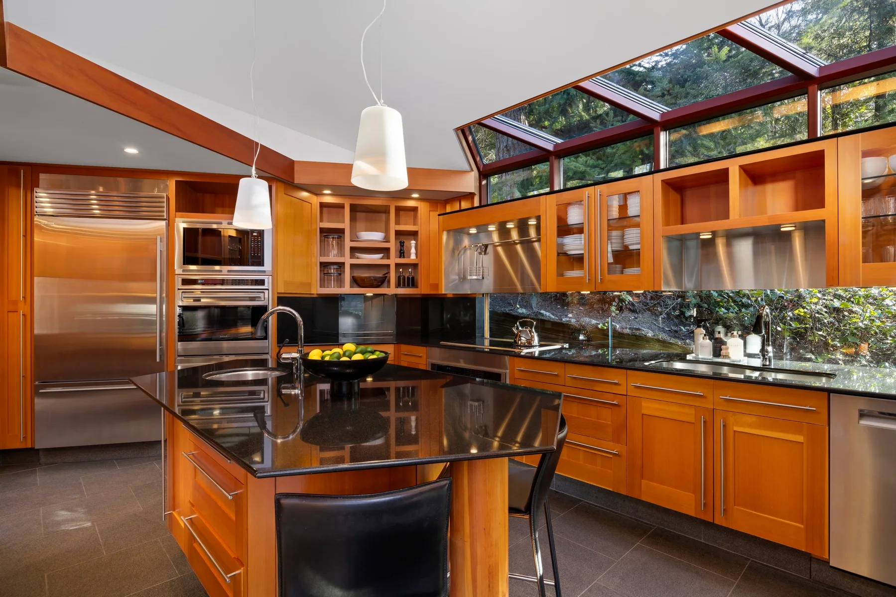 A modern kitchen with a central island and wood cabinetry.