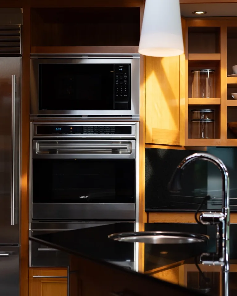 A modern kitchen with built-in appliances and a dark countertop.