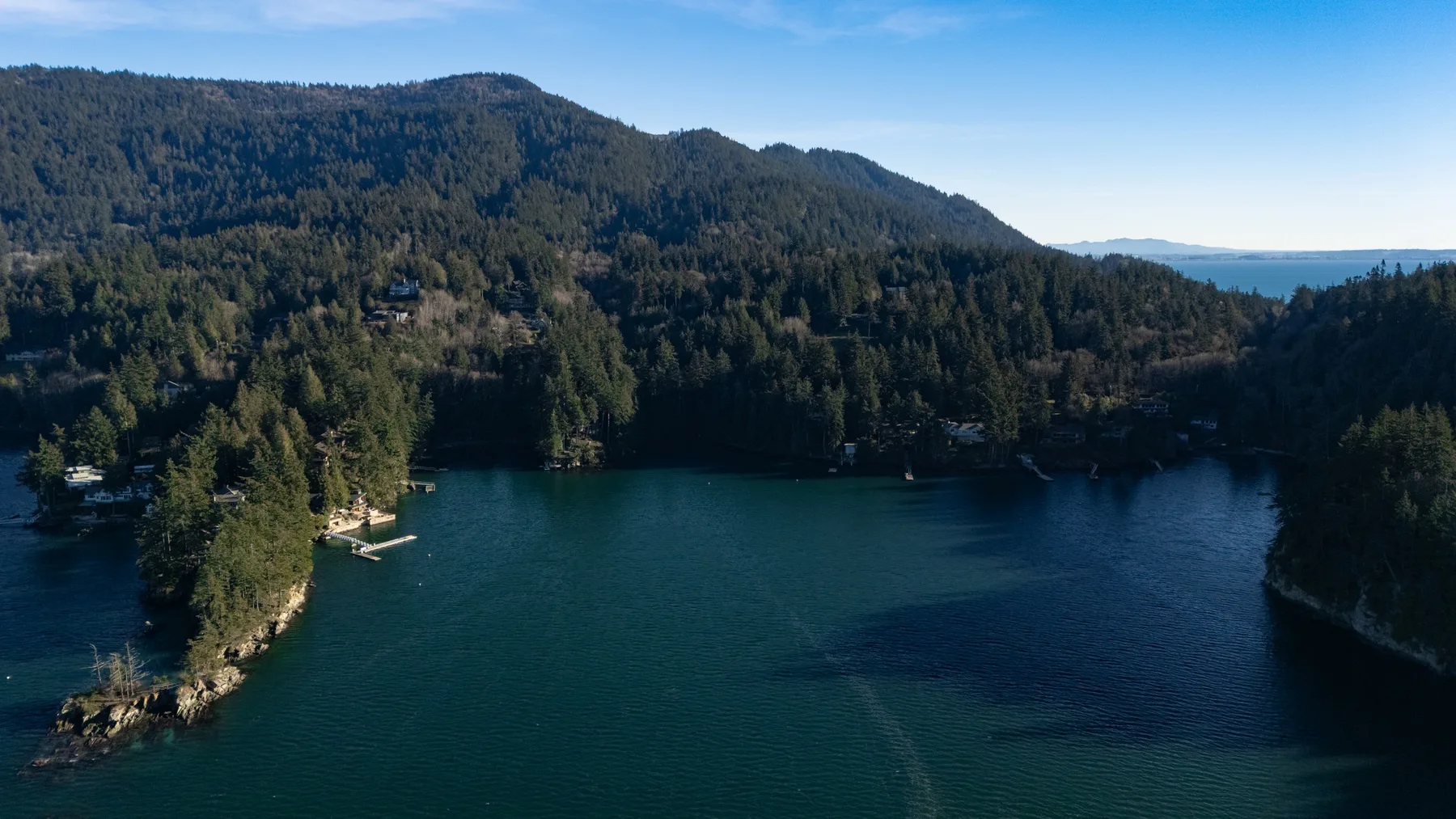 Aerial view of a lake bordered by forested hills.
