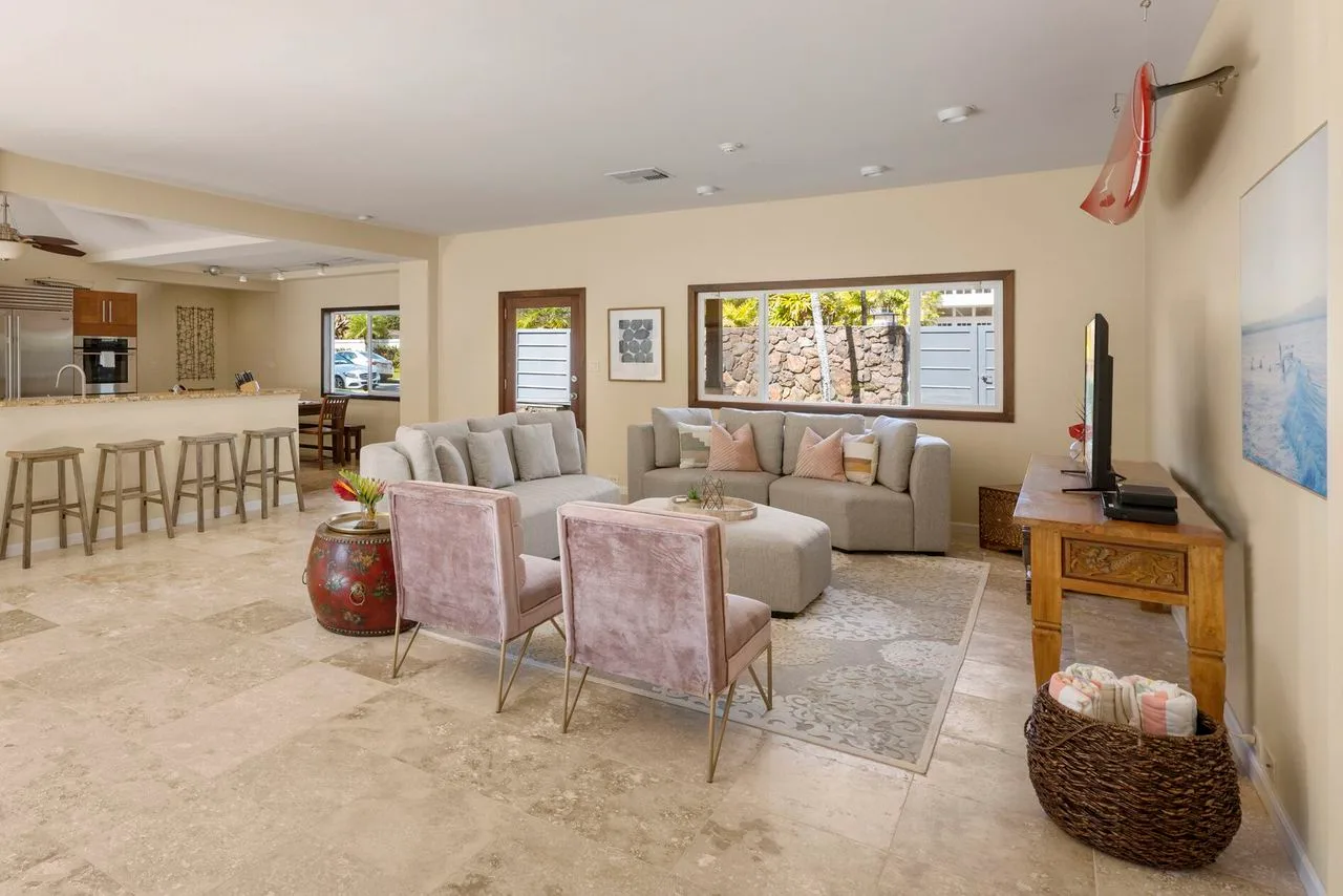 A living room with seating around a low table, next to an open kitchen.