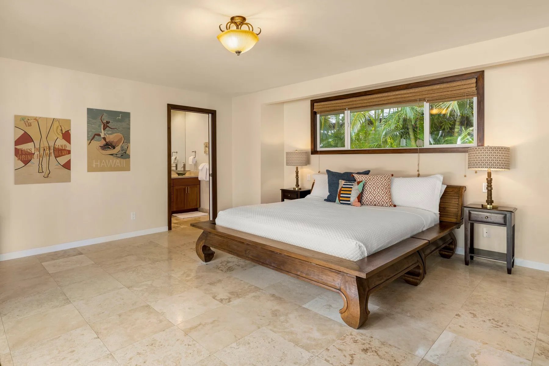 A bedroom with a wooden bed beneath a wide window overlooking greenery.