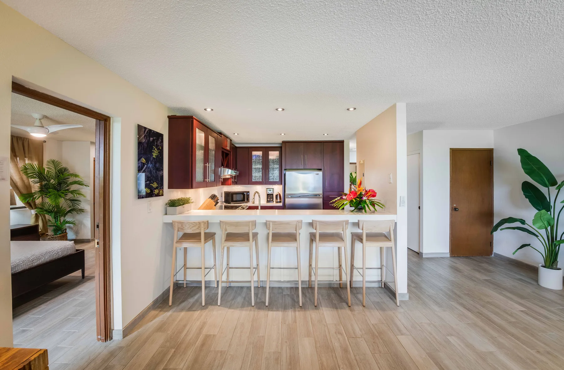 An open-plan kitchen and breakfast bar, with a dining area visible through the doorway.