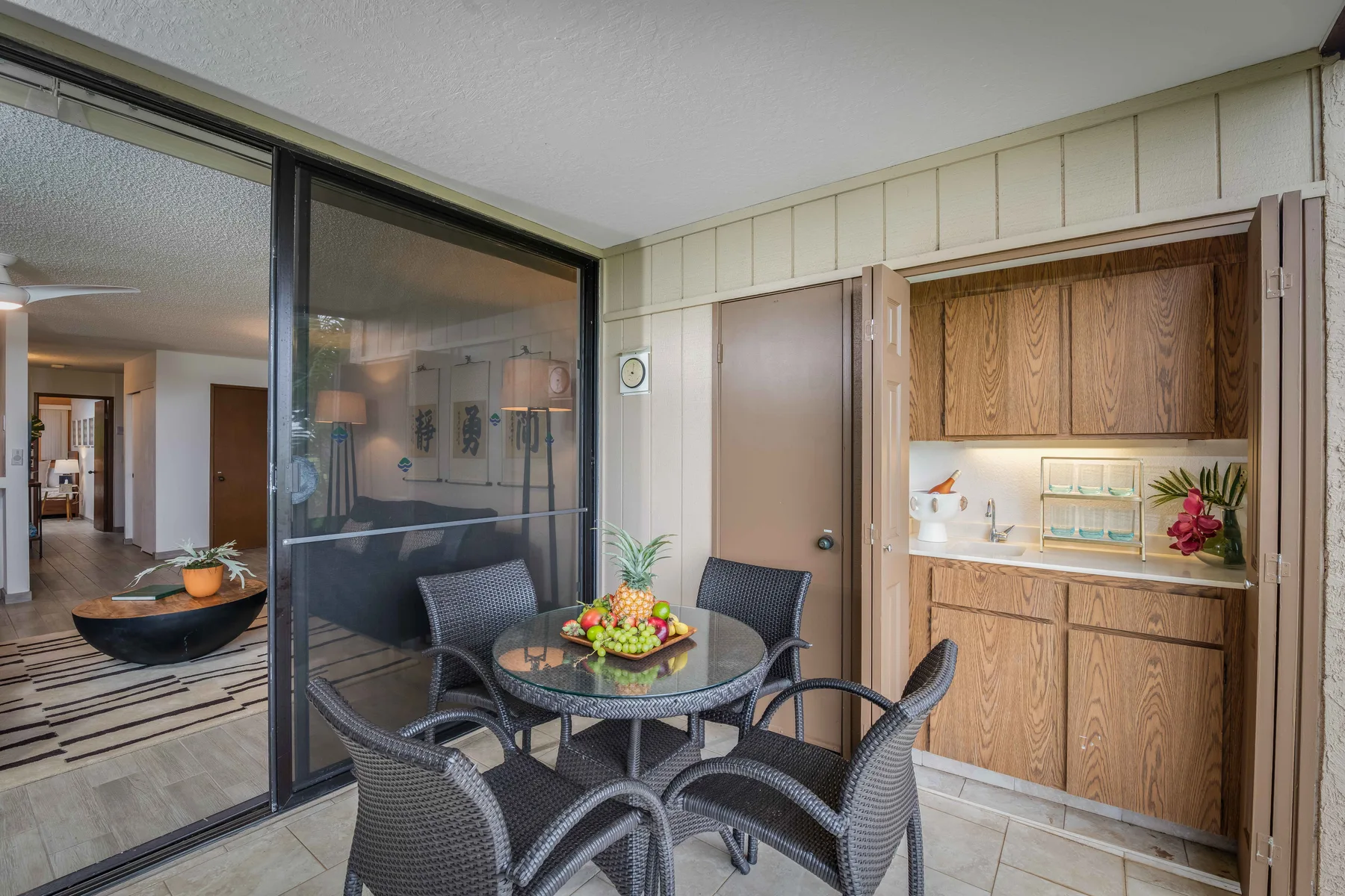 A patio dining area sits beside sliding glass doors and a built-in cabinet.